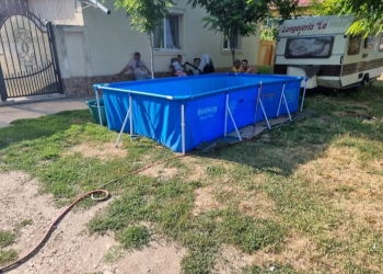 Între timp, la Grabaț. E pe fală: cu piscina în fața casei. Apa e pe social, de la fântâna publică