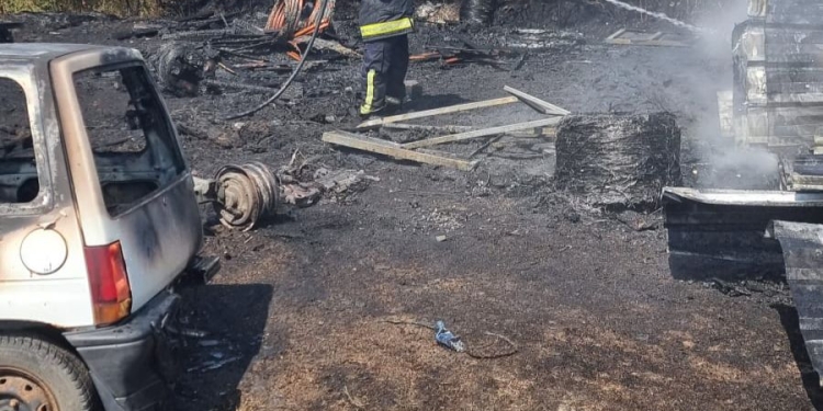 O mașina și două remorci făcute scrum, după un incendiu de vegetație